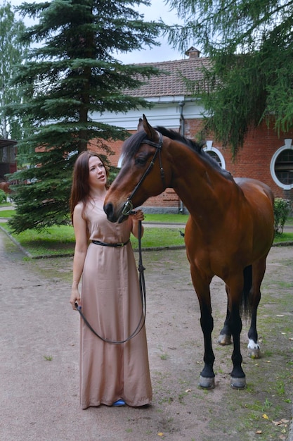 Jong meisje in een lange jurk met een paard