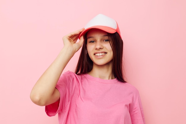 Jong meisje in een roze t-shirt met een pet op haar hoofd vrijetijdskleding