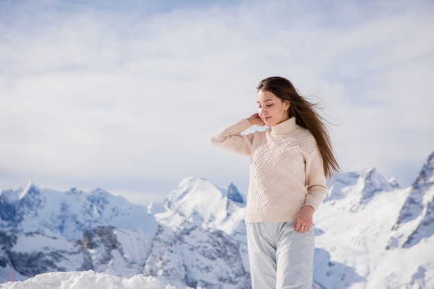 jong meisje in een winter pak kijken naar de bergen