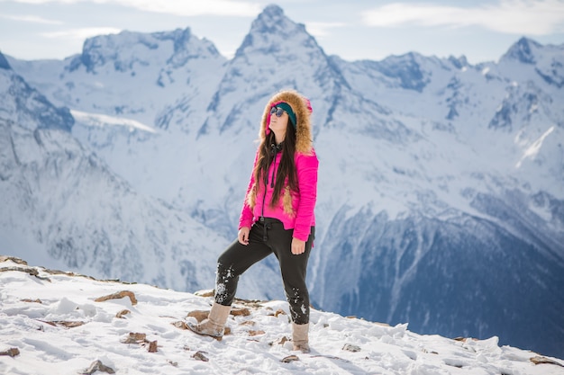 jong meisje in een winter pak kijken naar de bergen