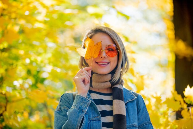 Jong meisje in het park in de tijd van het de herfstseizoen.