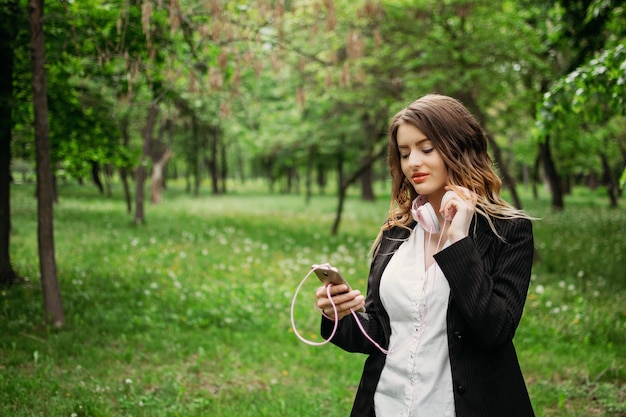 Jong meisje in hoofdtelefoons en met een smartphone