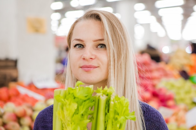 Jong meisje koopt groenten in de markt