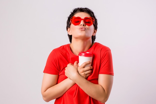 jong meisje lachend met een glas koffie op wit