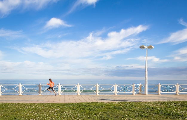 Jong meisje loopt in de strandpromenade op de zomer running