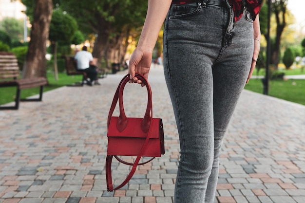 Jong meisje loopt in het park met een handtas
