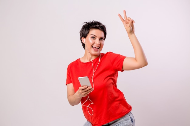 jong meisje, luisteren naar muziek aan de telefoon en dansen