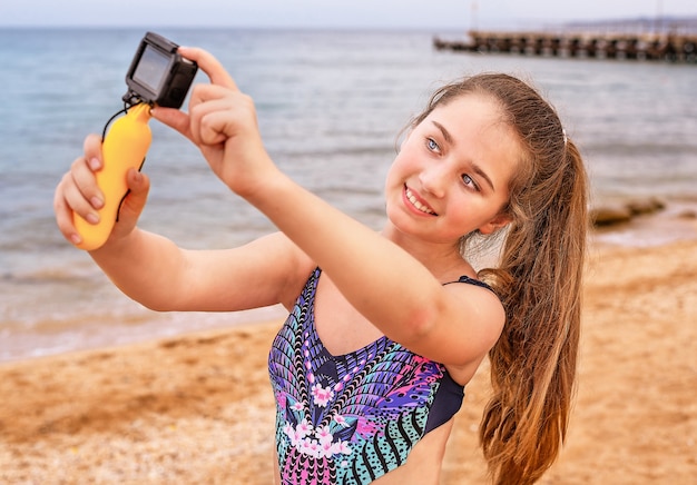 jong meisje maakt selfie en video op het strand.