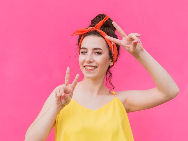 Foto jong meisje met bandana en vredestekengebaren