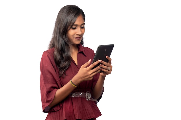 Jong meisje met behulp van mobiele telefoon of smartphone op een witte achtergrond