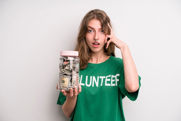 Jong meisje met een vrijwilligersconcept van de fles van de schenkingsbankbiljetten