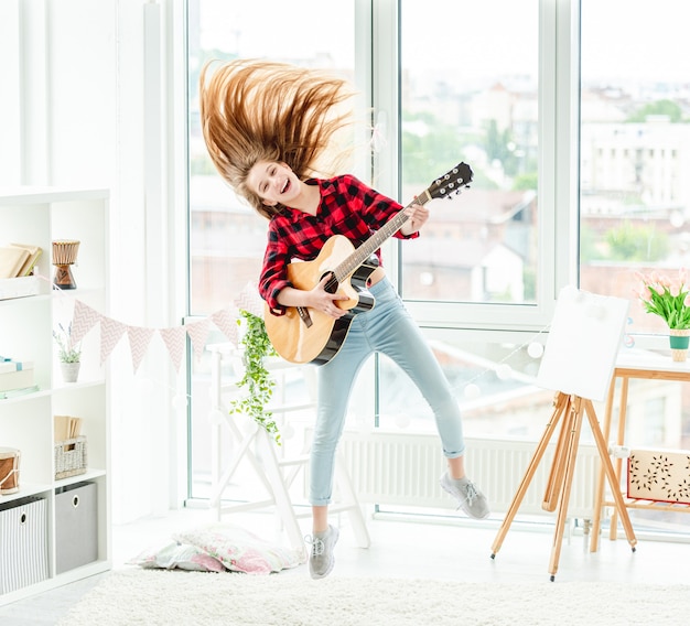 Jong meisje met gitaar in sprong