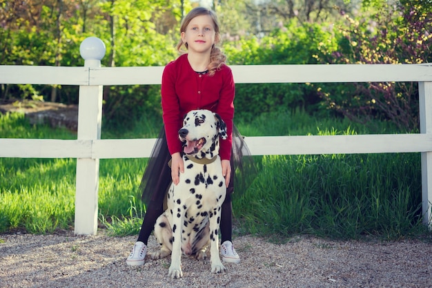 Jong meisje met haar Dalmatische honden in een de lentepark.