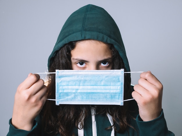 Jong meisje met haar gezicht dat door een masker wordt behandeld