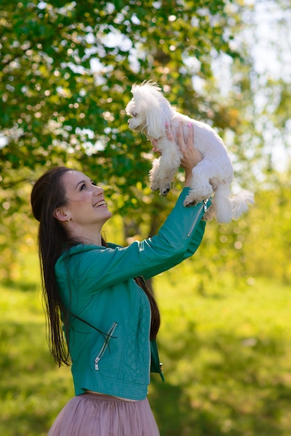 Jong meisje met haar hond. Puppy witte hond loopt met zijn eigenaar. Concept over vriendschap, dier en vrijheid.