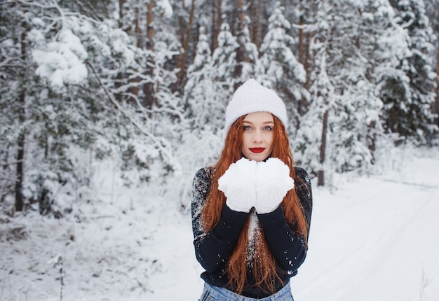 Jong meisje met lang rood haar op een winterlandschap.