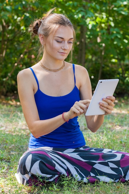 Jong meisje met laptop op het gras in het park