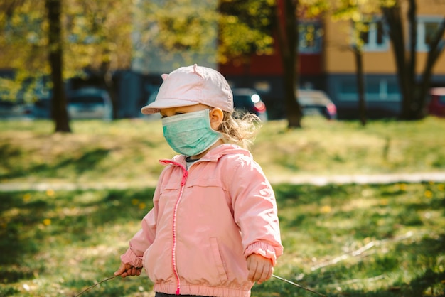 Jong meisje met masker buitenshuis