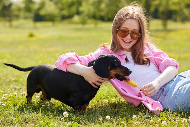 jong meisje met teckel hond ijs eten op een zonnige dag