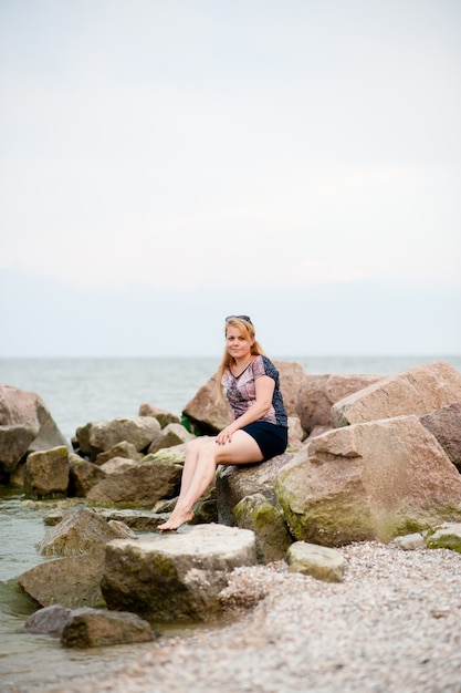 Jong meisje op de rotsen in de zee
