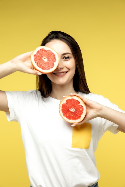 jong meisje poseren met grapefruit helften