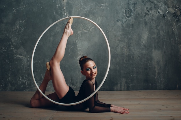 Jong meisje professionele turnster vrouw dans ritmische gymnastiek met hoepel in studio