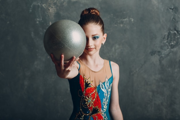 Jong meisje professionele turnster vrouw portret ritmische gymnastiek met bal in de studio.