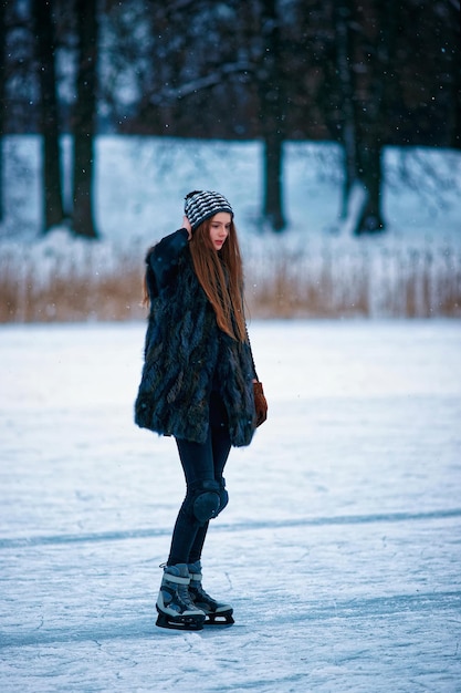 Jong meisje schaatsen op de winterbaan bedekt met sneeuw in Trakai, Litouwen.
