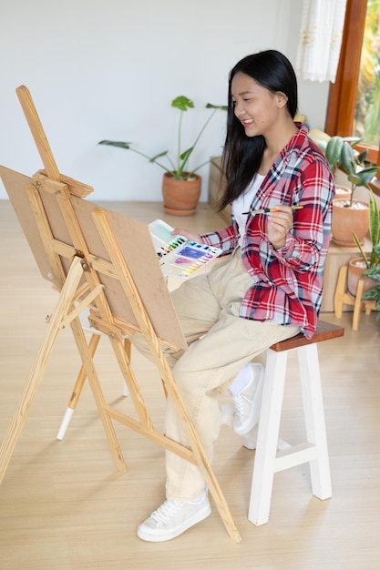 Jong meisje schilderen op papier thuis houten frameHobby en kunststudie thuis