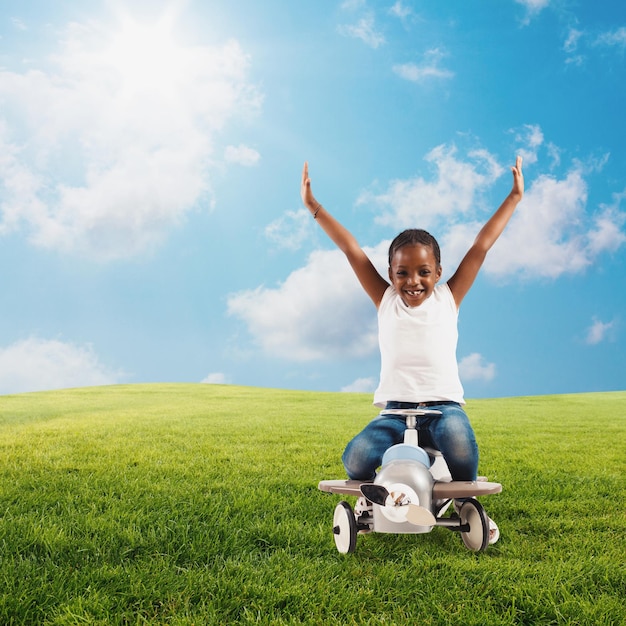 Jong meisje speelt met een vliegtuig speelgoed in een groen veld