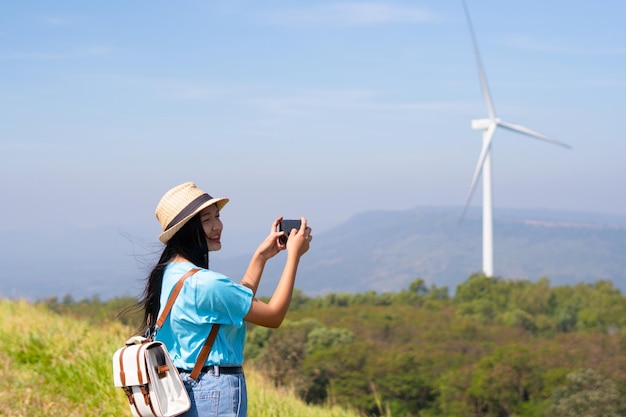 Jong meisje staat op de berg met prachtig landschapszicht en de windturbine bij Khao Yai Thieng Electric Wind Turbine Thailand