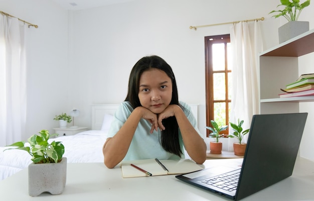 Jong meisje studeren met laptop in slaapkamer thuis leren