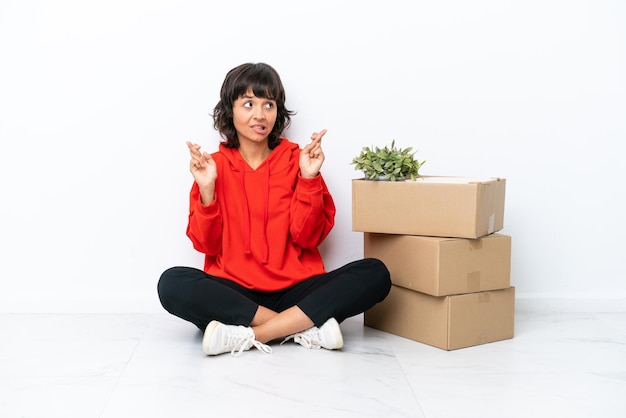 Jong meisje verhuizen in nieuw huis tussen dozen geïsoleerd op een witte achtergrond met vingers over elkaar