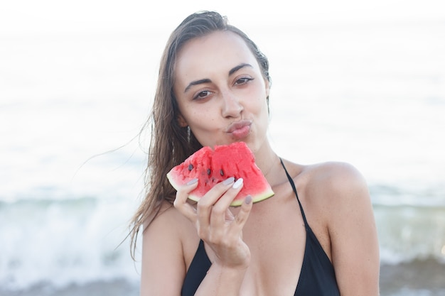 Jong meisje verse watermeloen eten op zandstrand sandy