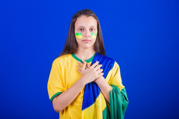Jong meisje voetbalfan uit Brazilië gekleed in vlag zingen volkslied Dankbaarheid