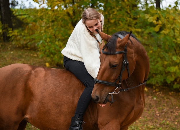 Jong meisje wandelen met een paard in de natuur.