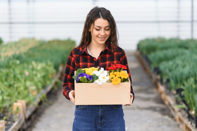 Jong meisje, werknemer met bloemen in kas