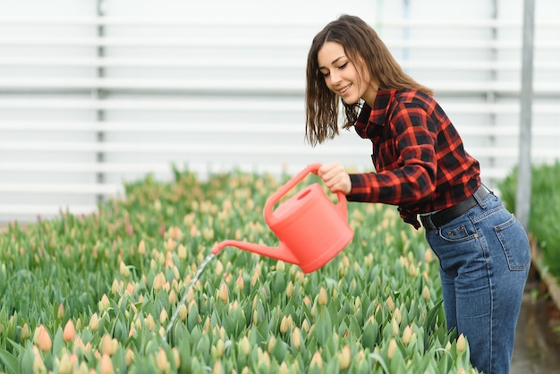 Jong meisje, werknemer met bloemen in kas