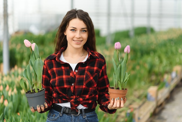 Jong meisje, werknemer met bloemen in kas