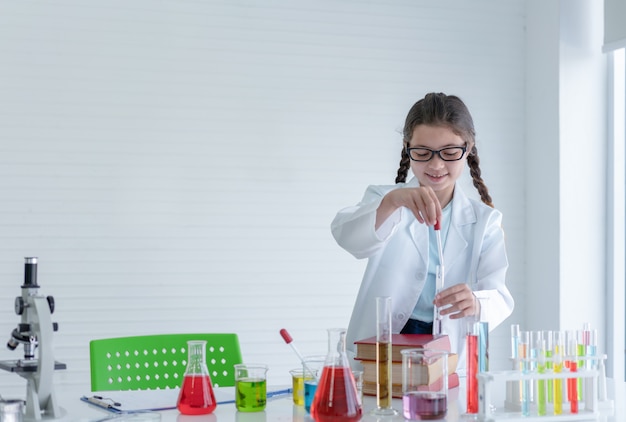 Jong meisje wetenschapper experimenten chemische maken in glazen buis in de laboratoriumruimte