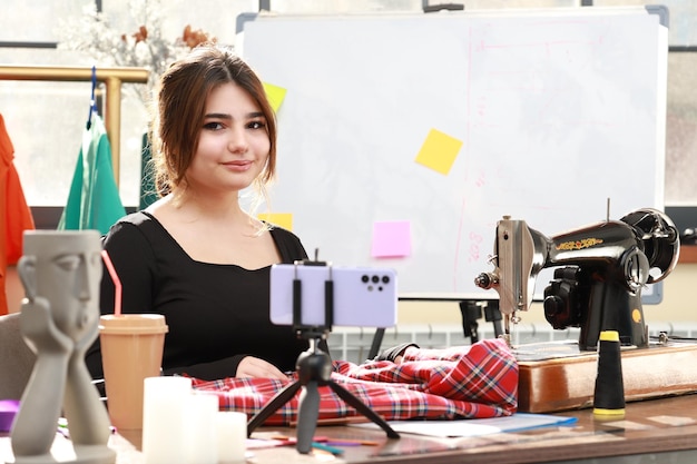 Jong meisje zit in het atelier en kijkt naar de camera