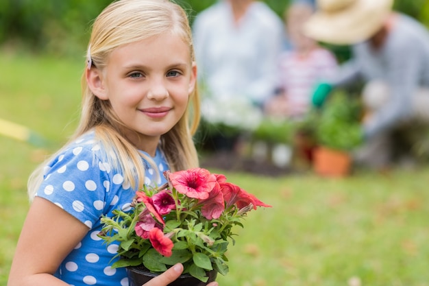 Jong meisje, zittend met bloempot