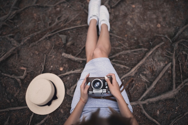 Jong meisje, zittend op de grond met een vintage camera