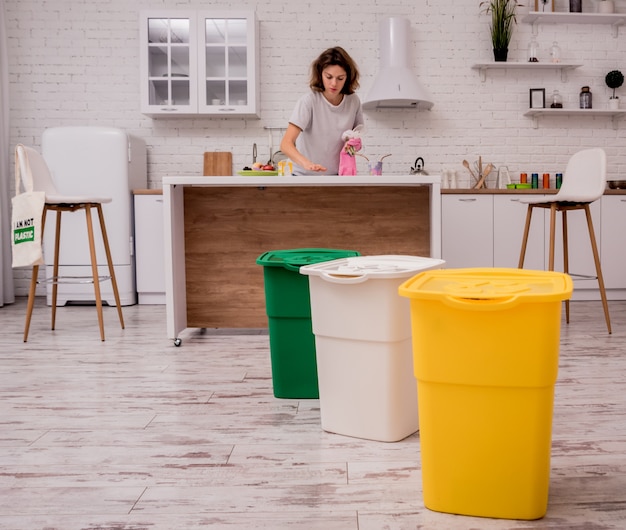 Jong meisjes sorterend huisvuil bij de keuken. Concept van recycling. Zero waste