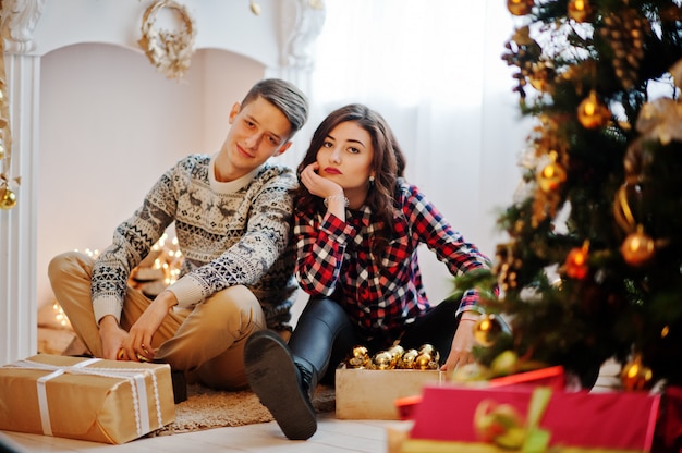 Jong modieus paar met Kerstmisgiften en Nieuwjaardecoratie