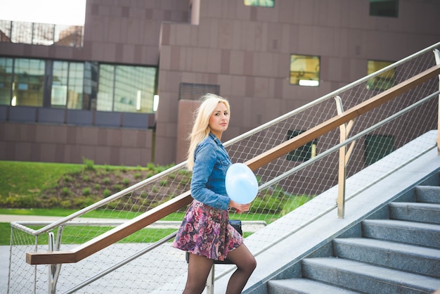 Jong mooi Kaukasisch blonde meisje in de stad