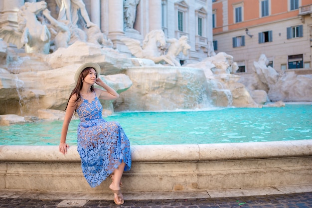 Foto jong mooi meisje dichtbij fontein fontana di trevi met stadskaart