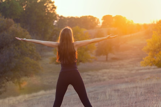 Foto jong mooi meisje doet yoga in de natuur.