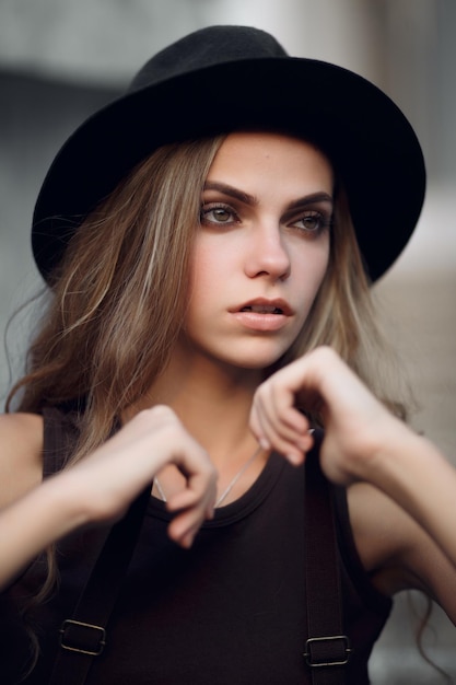 jong mooi meisje in een korte elegante top en zwarte hoed
