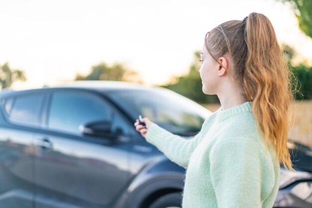 Jong mooi meisje met autosleutels in de open lucht